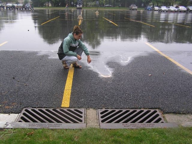 Girl standing near large puddle of water